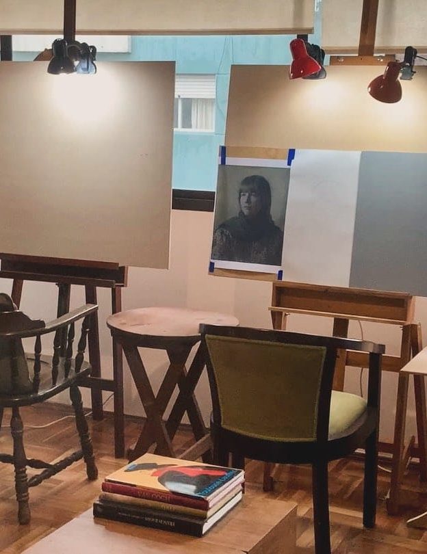 Taller de dibujo en Montevideo con caballetes, luces de estudio y retrato en proceso